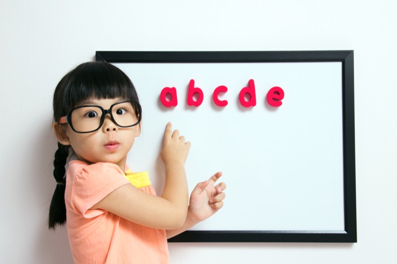 Conciencia fonológica La imagen muestra a una niña indicando unas letras en una pizarra
