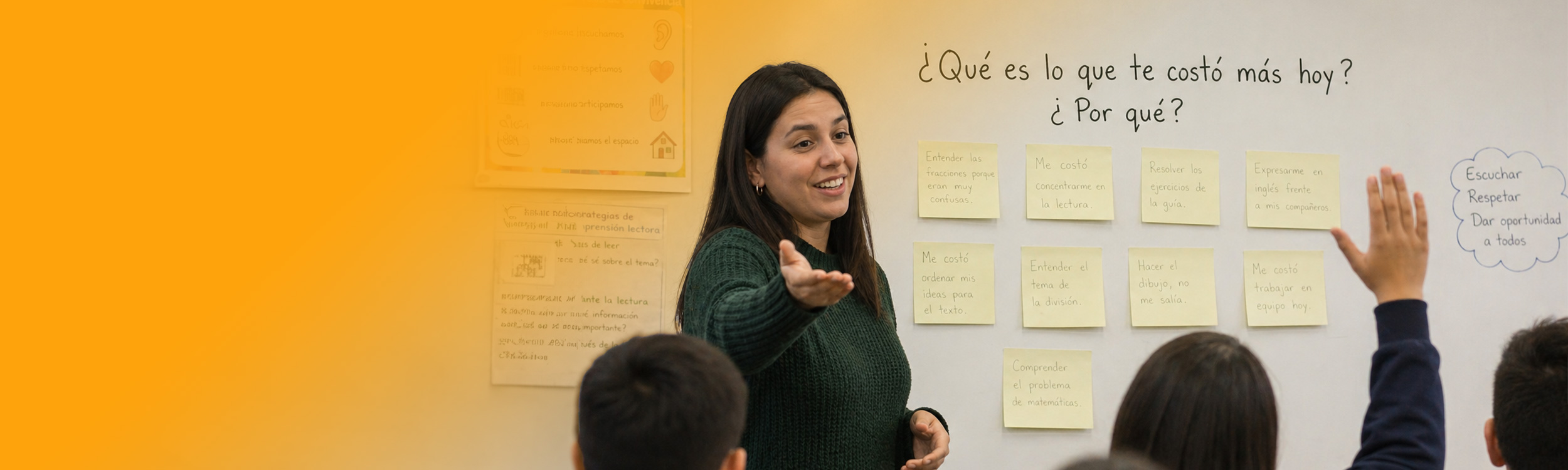 Fotografía de docente conversando con estudiantes en sala de clases.
