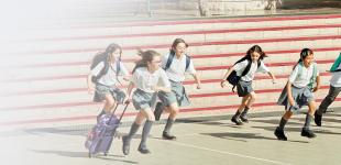 Ninos y niñas vestidos con uniforme escolar corriendo hacia la misma dirección.