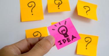 La imagen muestra una pared con 5 post-it con signos de interrogación en torno a la palabra dea