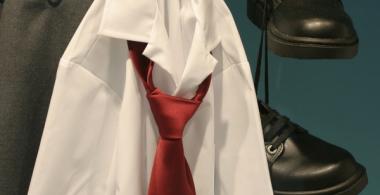 La imagen muestra un uniforme escolar de varón colgado de un perchero