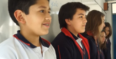 Estudiantes están de pié frente a su curso contando su experiencia