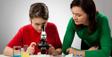 Adolescente observando muestras con un miscroscopio