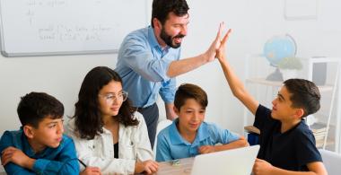 Profesor chocando la mano de uno de los estudiantes de su grupo de estudio